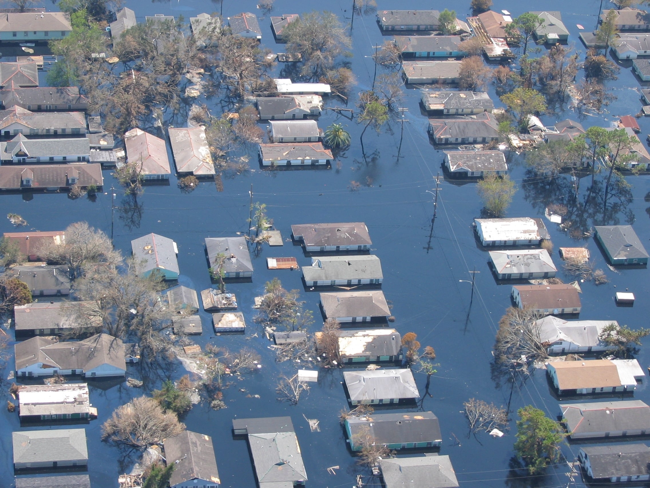 View of a flooded neighborhood from above. Tops of houses are just visible over the water level.