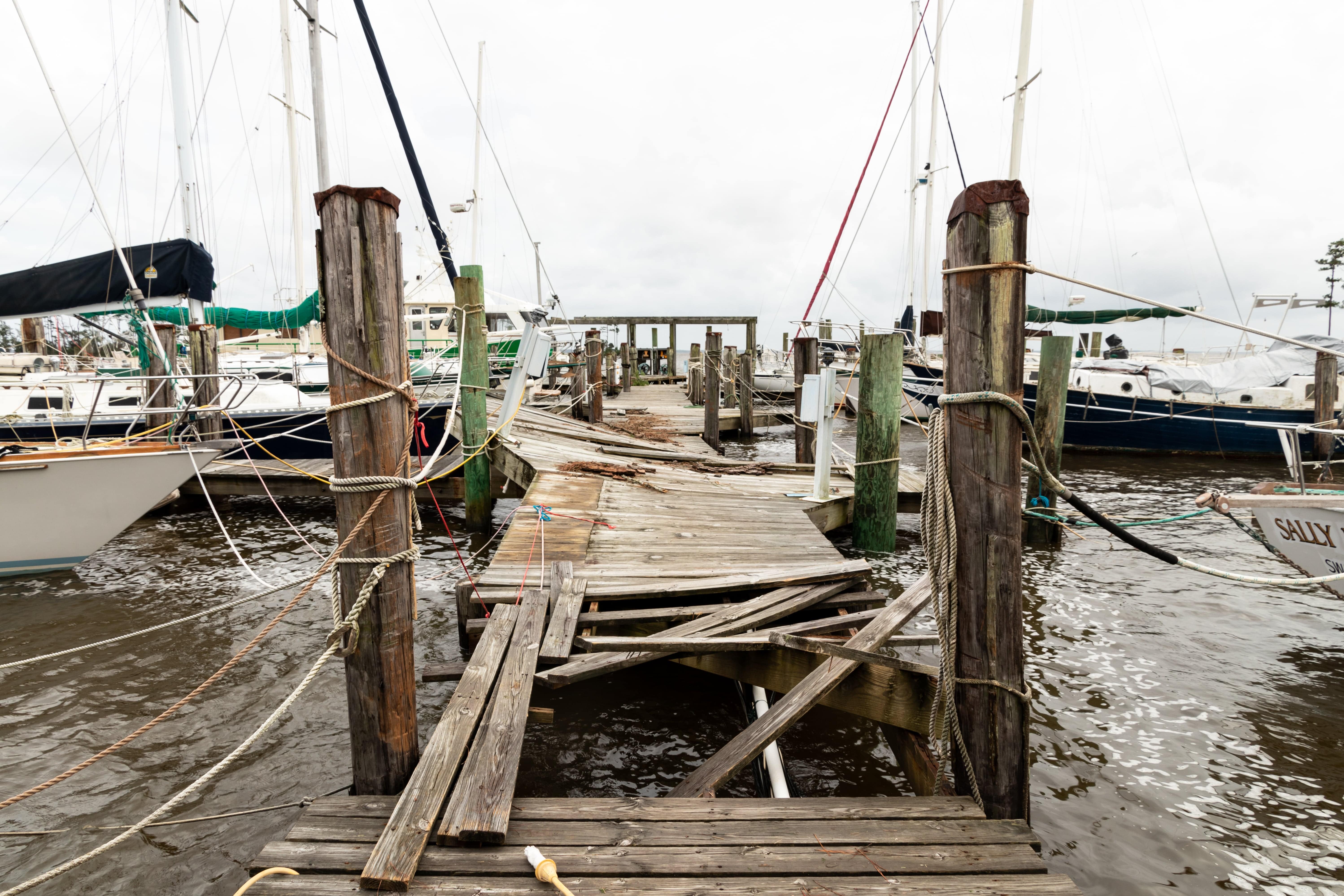 A damaged wooden dock at a marina.