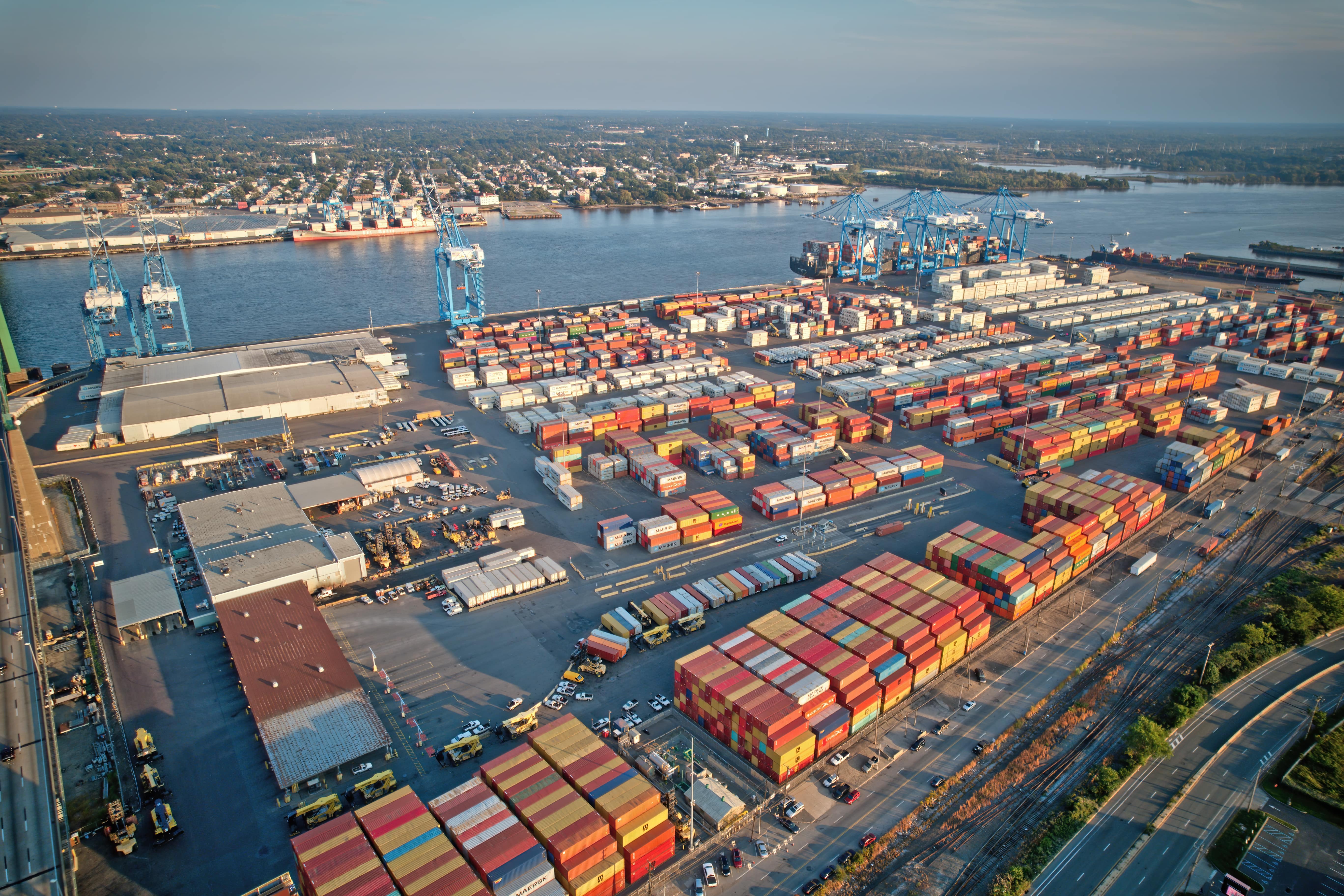 Aerial view of port terminal with stacks of colorful shipping containers. 