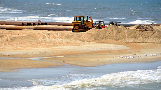 Photo of bulldozer doing construction on the beach