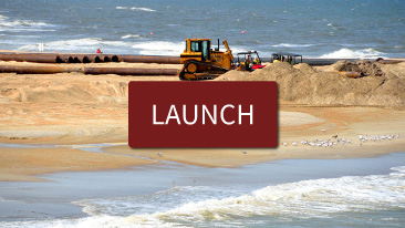 Red launch button over beach being bulldozed. 