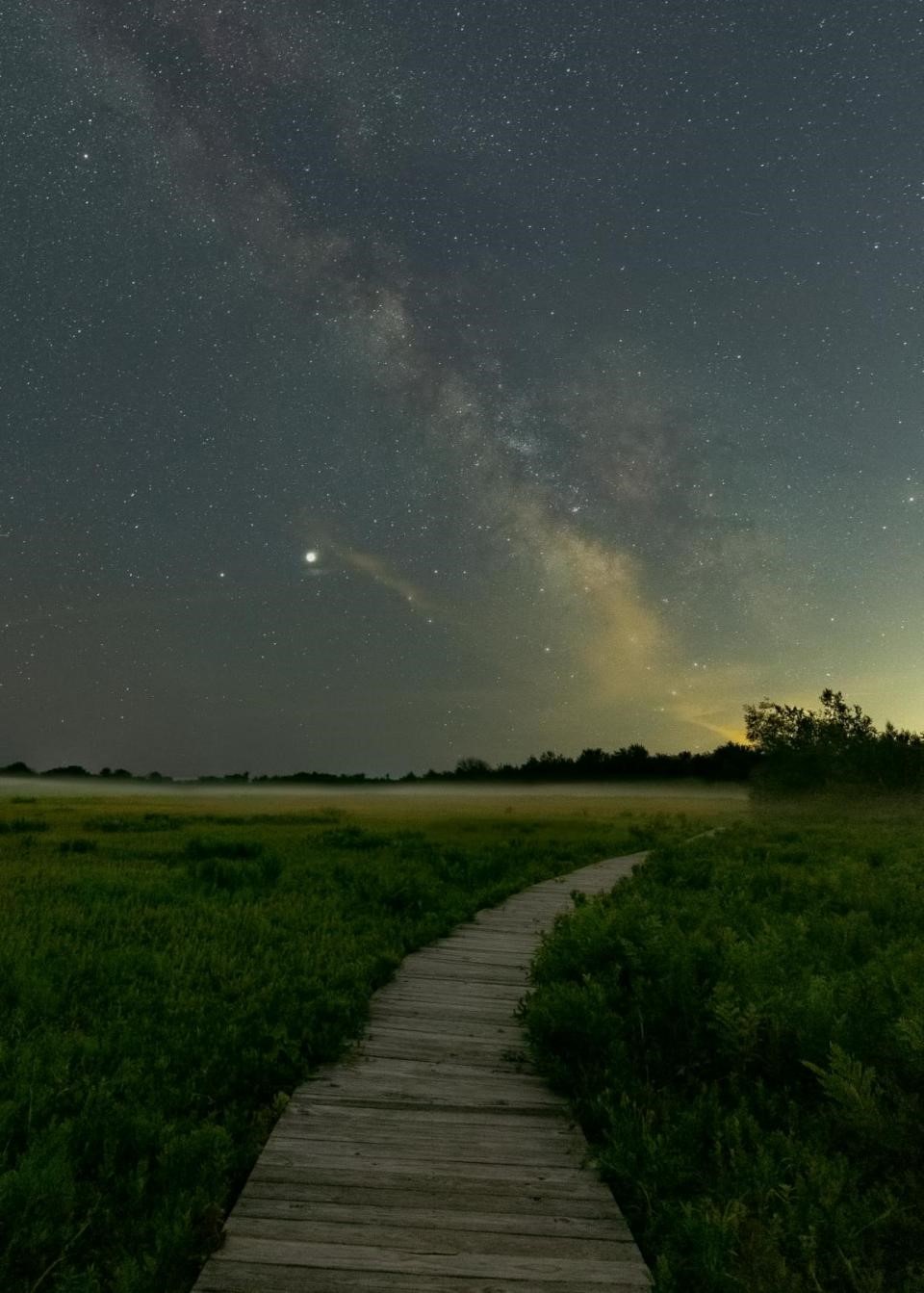 Image of a boardwalk under a starry night sky at Wells Reserve, Maine