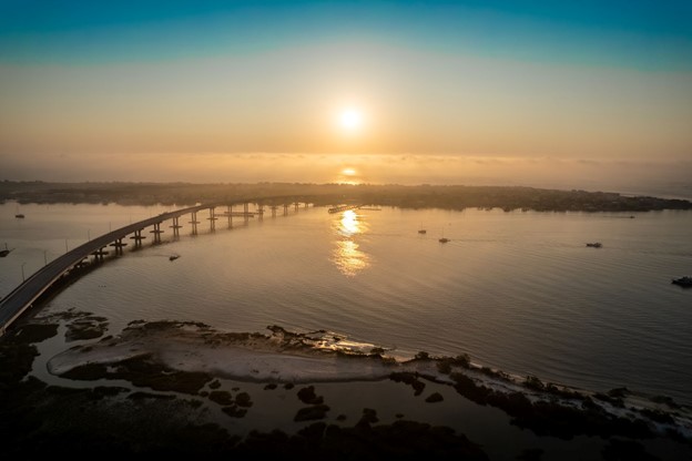 Aerial view of a bridge going over coastal waterway.