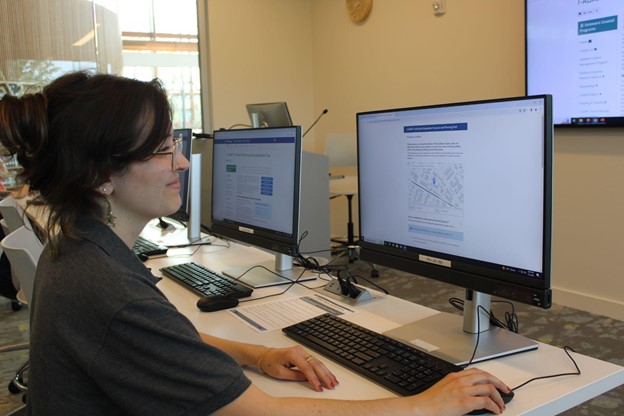 An employee looks at the I-ADAPT tool on a computer screen in a conference room.