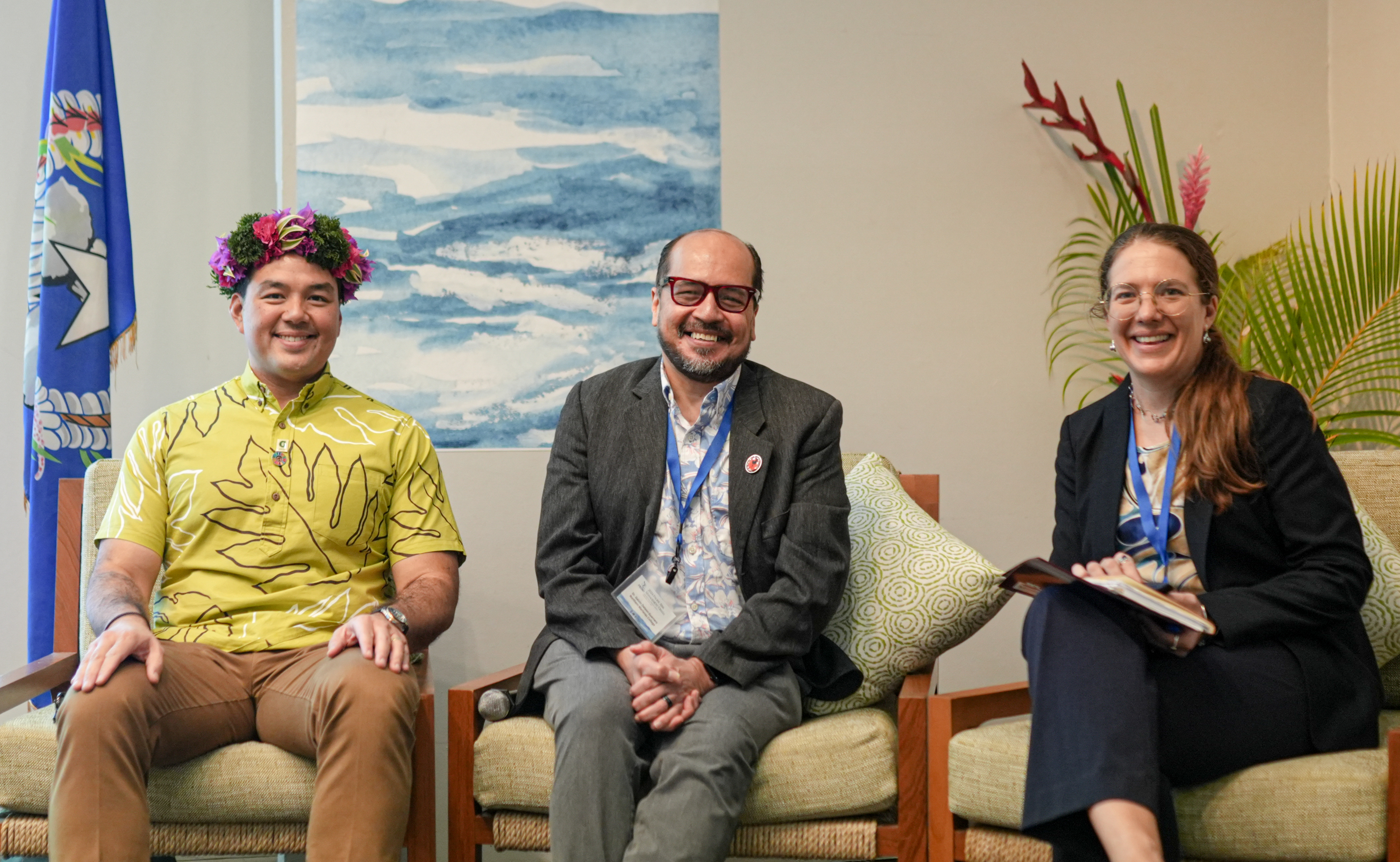 Three people sitting in chairs and smiling