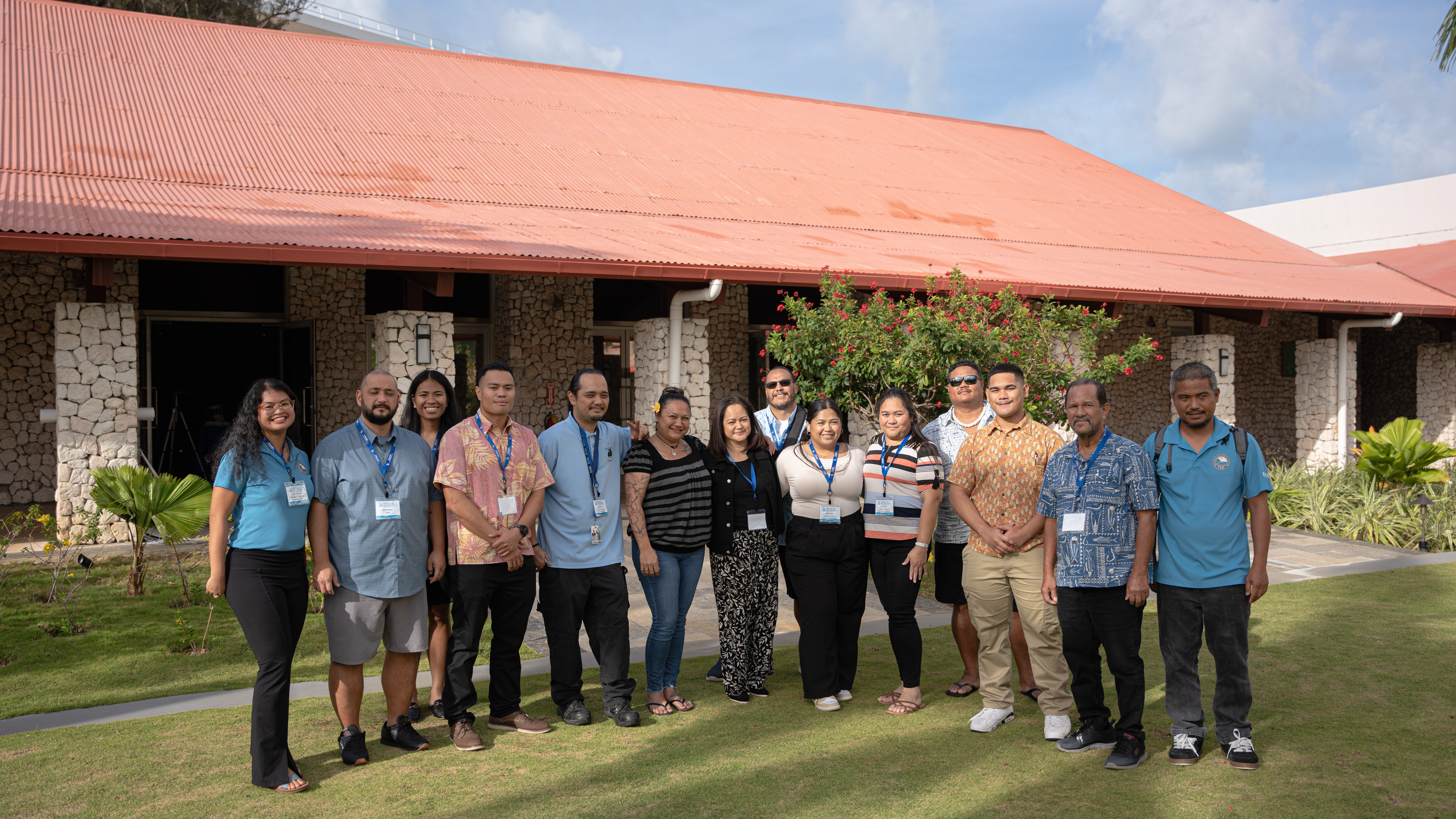 A group of people smiling in front of a building